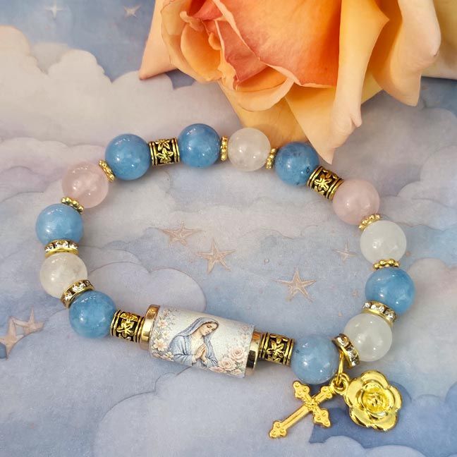 Bracelet with rose quartz, clear quartz, blue chalcedony beads, Mary centerpiece, and small golden cross and rose charms.