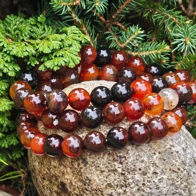 Carnelian bracelet with beads in orange, caramel, amber, and warm brown tones symbolizing warmth and courage.