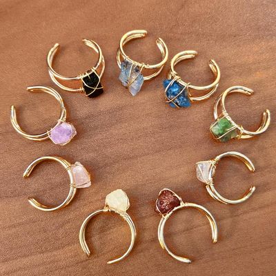 Hand‑wrapped raw gemstone ring with adjustable brass band and natural stone.