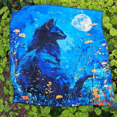 Black cat gazing at full moon amid blue wildflowers on mystical altar cloth.