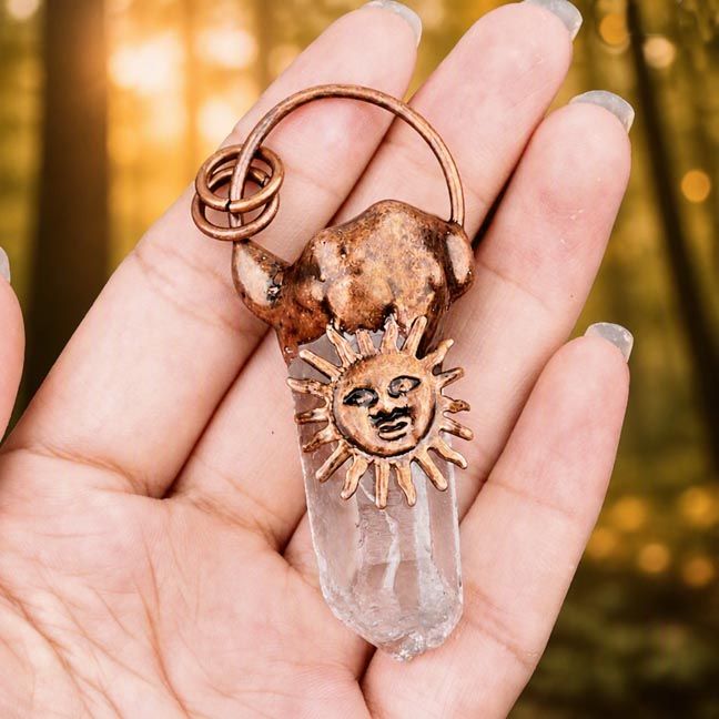 Copper sun pendant with clear quartz point on waxed cotton cord