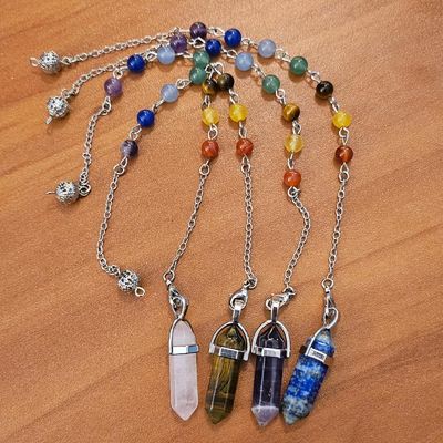 Celestial Flow gemstone pendulum with chakra chain, featuring hexagonal crystal point and healing stones.
