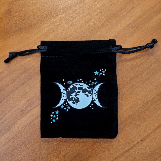 Soft velveteen pouch with moons and stars printed in vibrant celestial artwork.