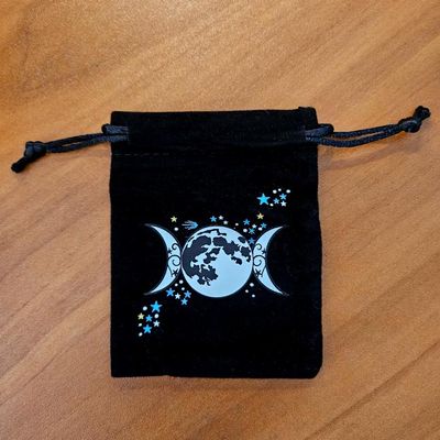 Soft velveteen pouch with moons and stars printed in vibrant celestial artwork.