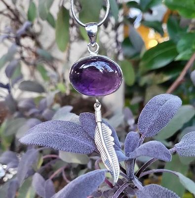 Handmade sterling silver pendant with a 3/4" Amethyst cabochon and silver feather, 2½" long, on an 18" chain.