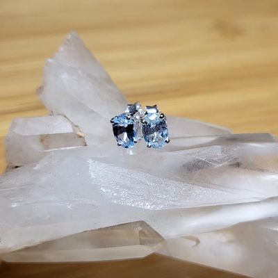 Small handmade sterling silver stud earrings with oval faceted Blue Topaz gemstones.