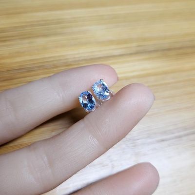 Small handmade sterling silver stud earrings with oval faceted Blue Topaz gemstones.