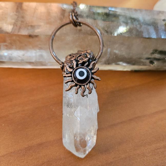 Clear Quartz Twin Flames point wrapped in antique copper with sun motif and Evil Eye bead