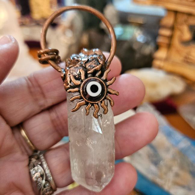 Clear Quartz Twin Flames point wrapped in antique copper with sun motif and Evil Eye bead