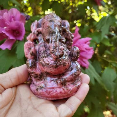 Hand‑carved Rhodonite Ganesh statue with deep pink stone and dark natural contrast.
