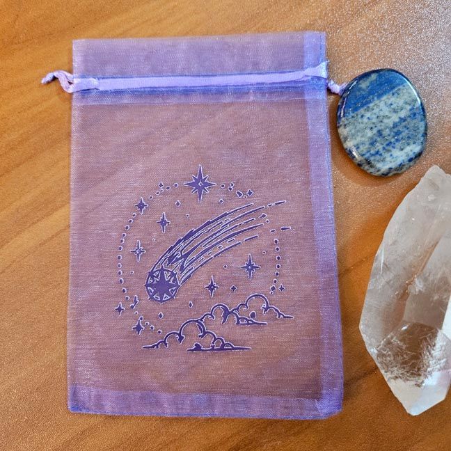 Purple organza bag with comet streaking through stars and clouds.