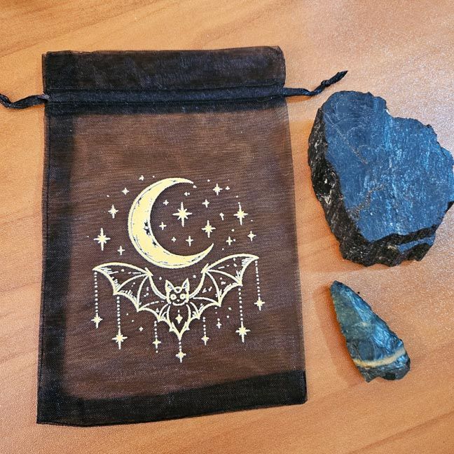 Black organza bag with golden crescent moon, bat, and stars printed design.