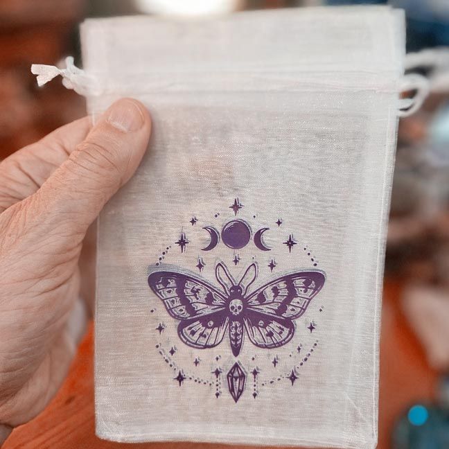 White organza bag with violet moth, moon phases, and crystal printed design.