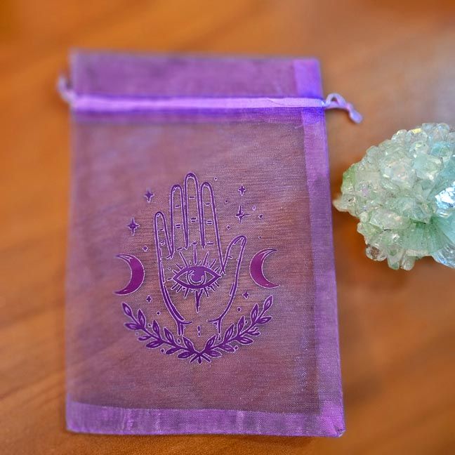 Purple organza bag with protective hand and Evil Eye printed design.