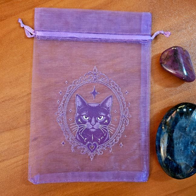 Purple organza bag with mystical cat surrounded by stars and ornate celestial design.