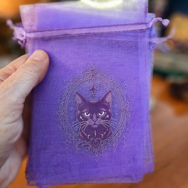 Purple organza bag with mystical cat surrounded by stars and ornate celestial design.