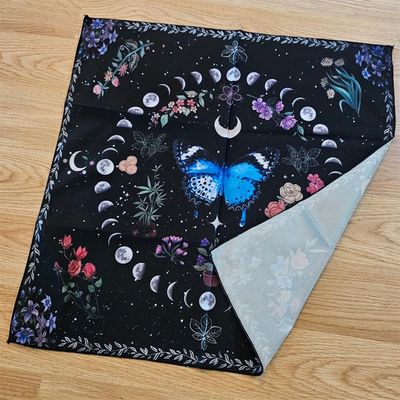 Black altar cloth with blue butterfly, moon phases, and colorful floral celestial design.