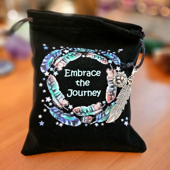 Black velveteen pouch with feather mandala, “Embrace the Journey” text, and silver feather charm.