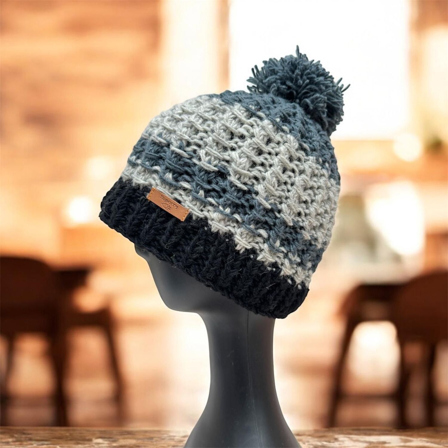 Bommel Mütze in Grau und Schwarz , Handgestrickt aus reiner Wolle und mit Polarfleece Innen gefüttert.  Unter fairen Bedingungen in Nepal hergestellt, Original Poporry Mütze