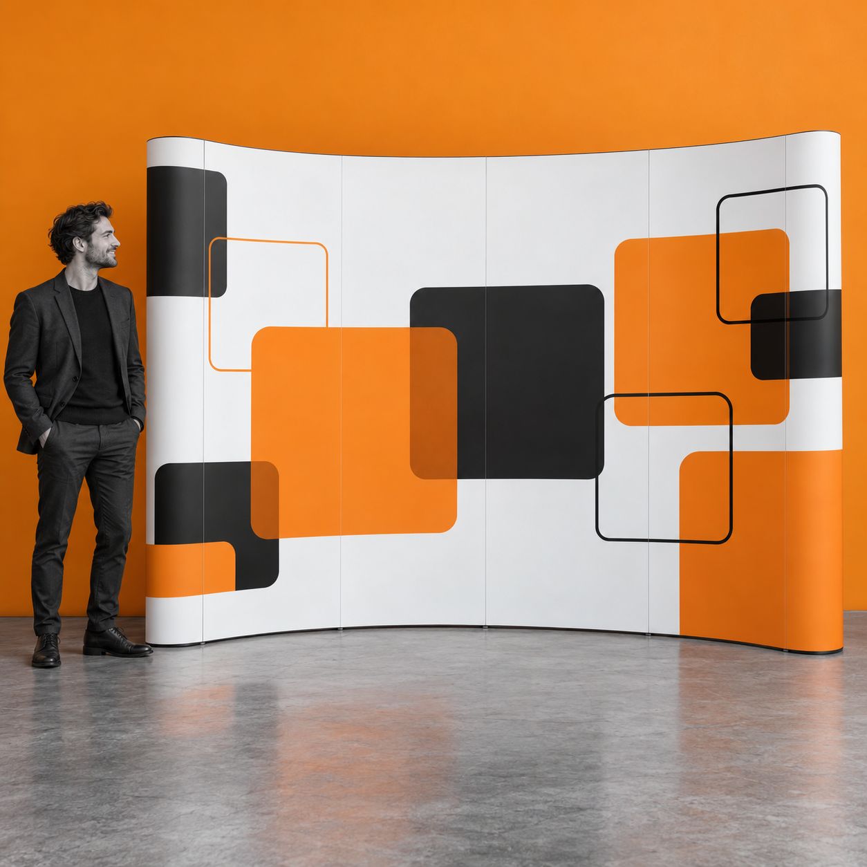 4 × 3 Curved Pop-Up Display Wall with Print A curved 4 × 3 pop-up display with geometric print beside a person in an exhibition space.