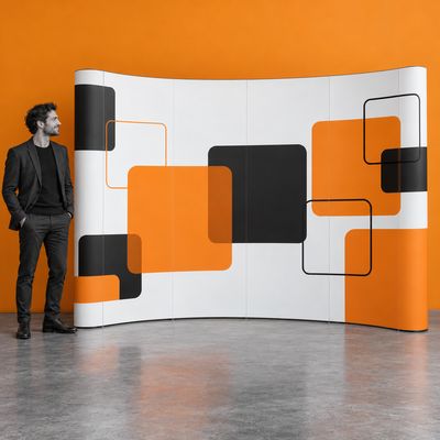 A curved 4 × 3 pop-up display with geometric print beside a person in an exhibition space.
