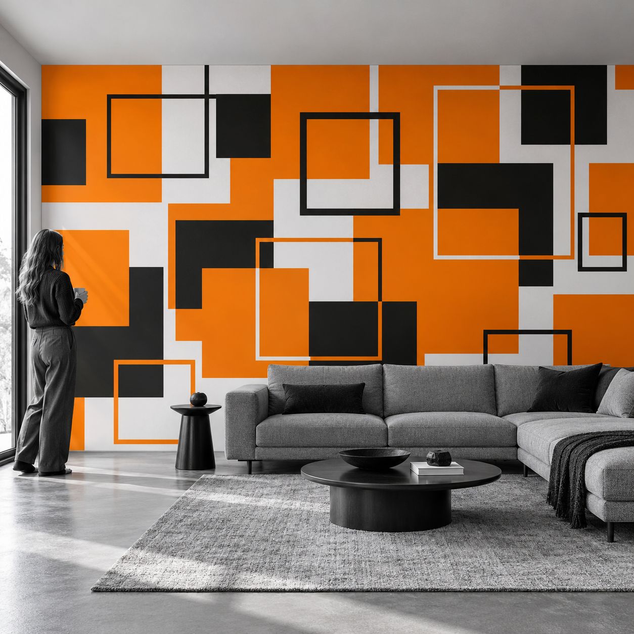 Fototapeta 400 × 260 cm z oranžno, črno in belo geometrijo na steni sivinsko opremljene sobe.