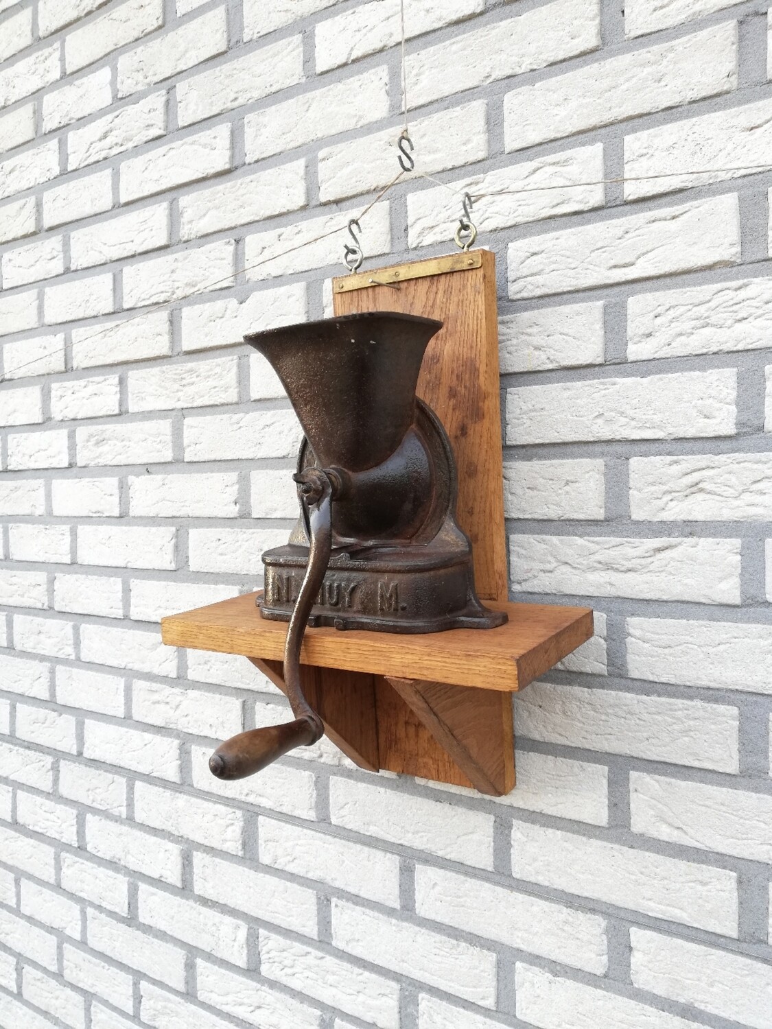 Antieke koffiemolen op wandplankje