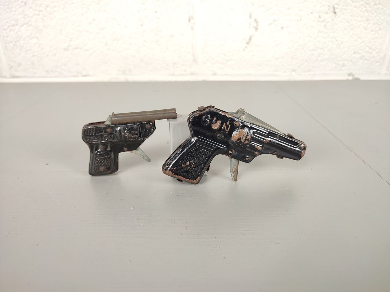 2 old tin toy guns