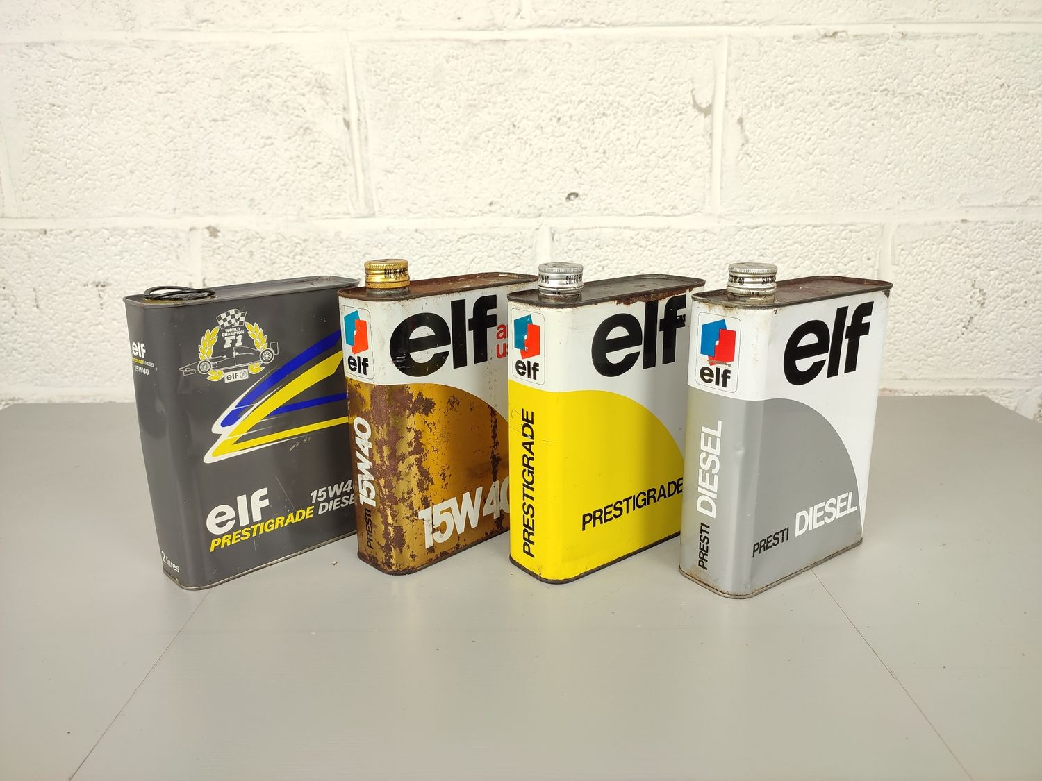 4 old Elf oil cans