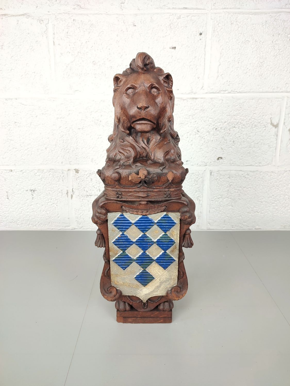 Antique wooden lion holding a coat of arms
