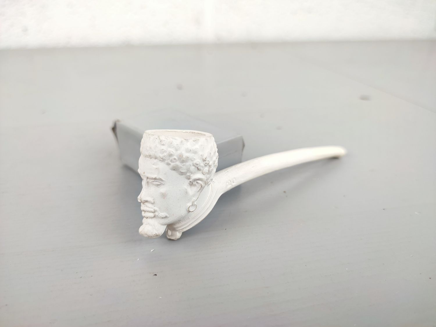 Old clay pipe with head