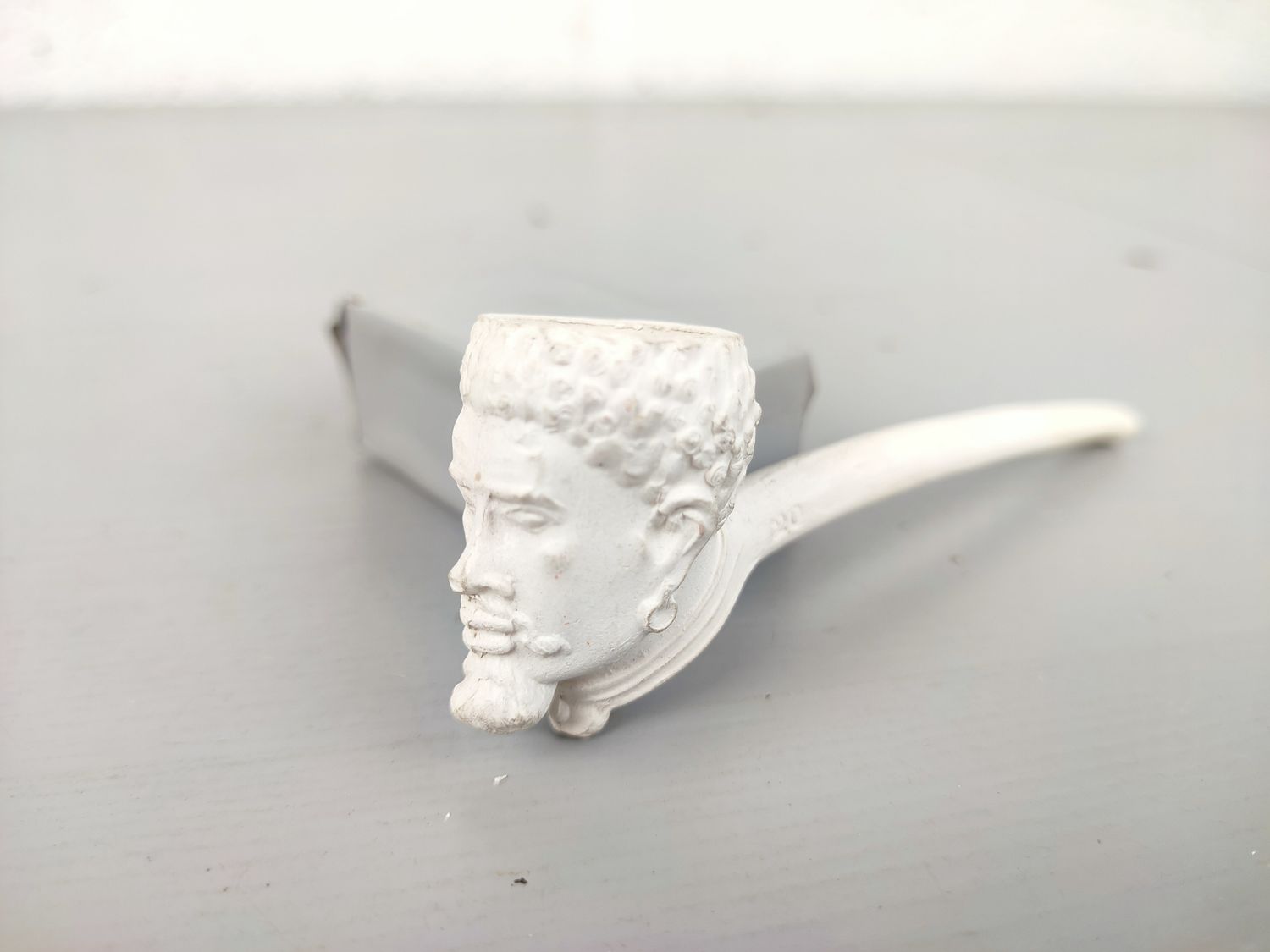 Old clay pipe with head
