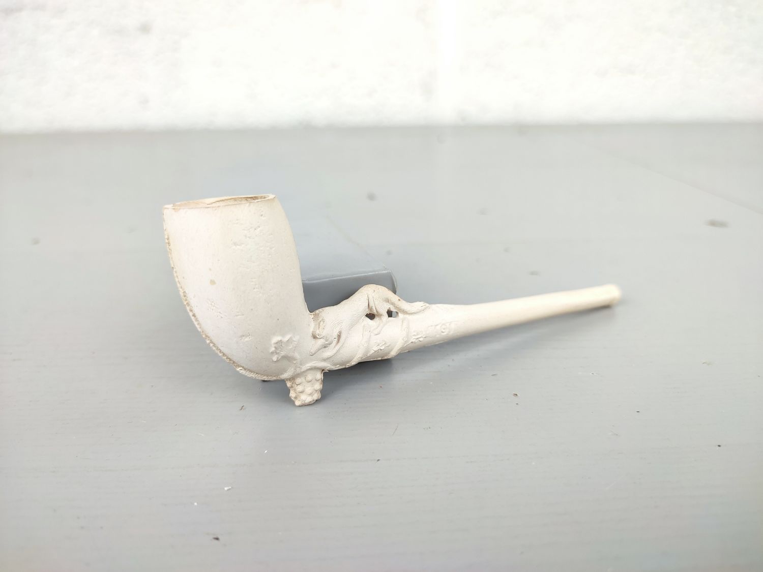Old clay pipe with fox and grapes