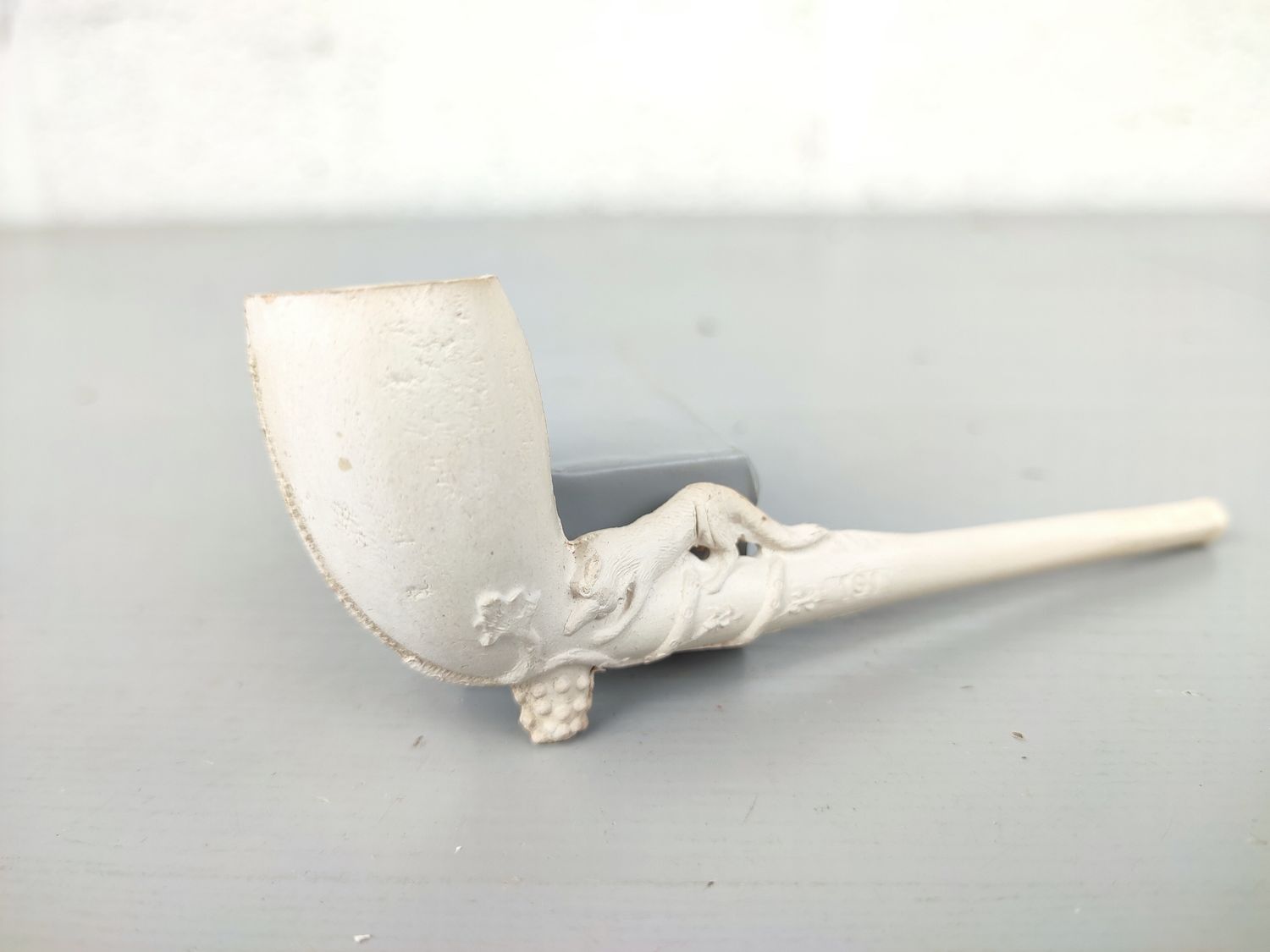 Old clay pipe with fox and grapes
