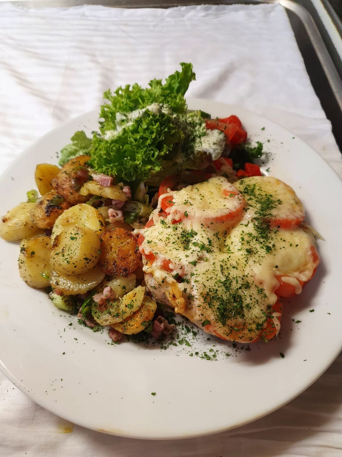 ​Schweinesteak mit Tomate und Käse überbacken