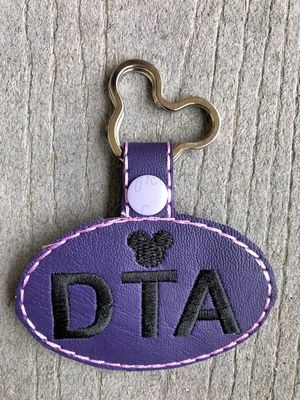 DTA Dis Travel Agent in oval Key Fob, both short and long tab, velcro or snaps, THREE SIZES in the hoop Machine Applique Embroidery Design- 4", 7", and 10"