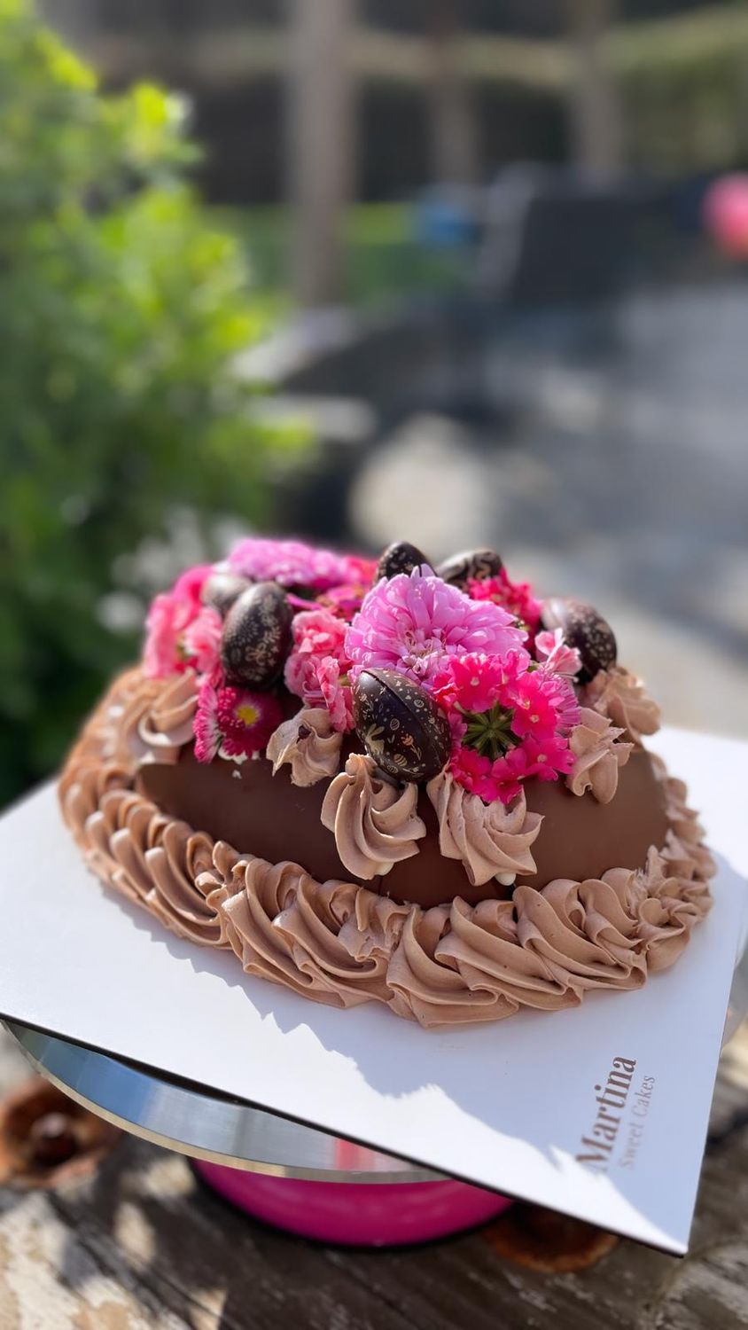 Ou decorat amb crema de Nutella, flors comestibles i martell de fusta per trencar-ho