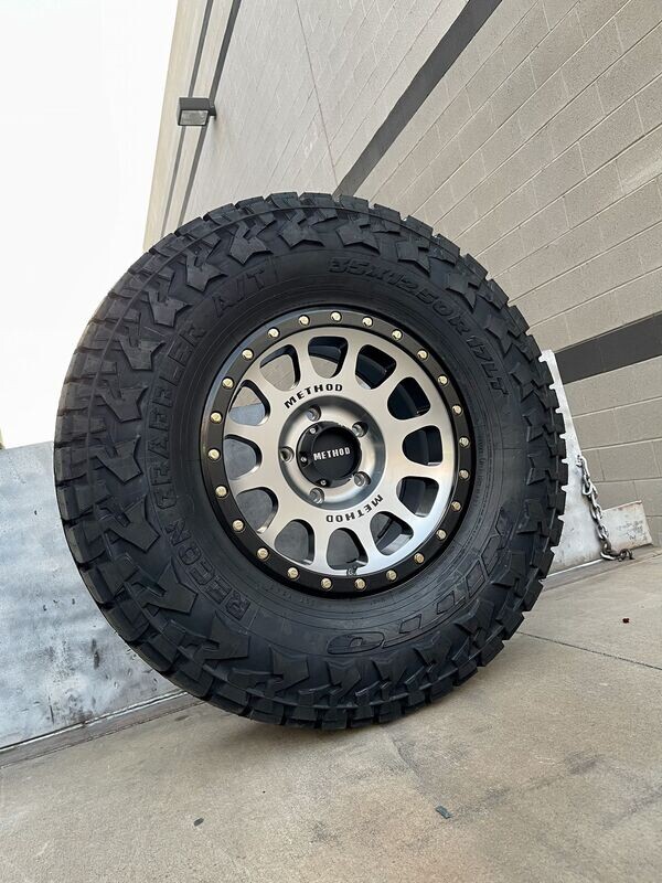Wheel & Tire Method Race 17x8.5 6x135 Black Machine Face Wheels & 285-70-17 Nitto Recon Grappler A/T Tires