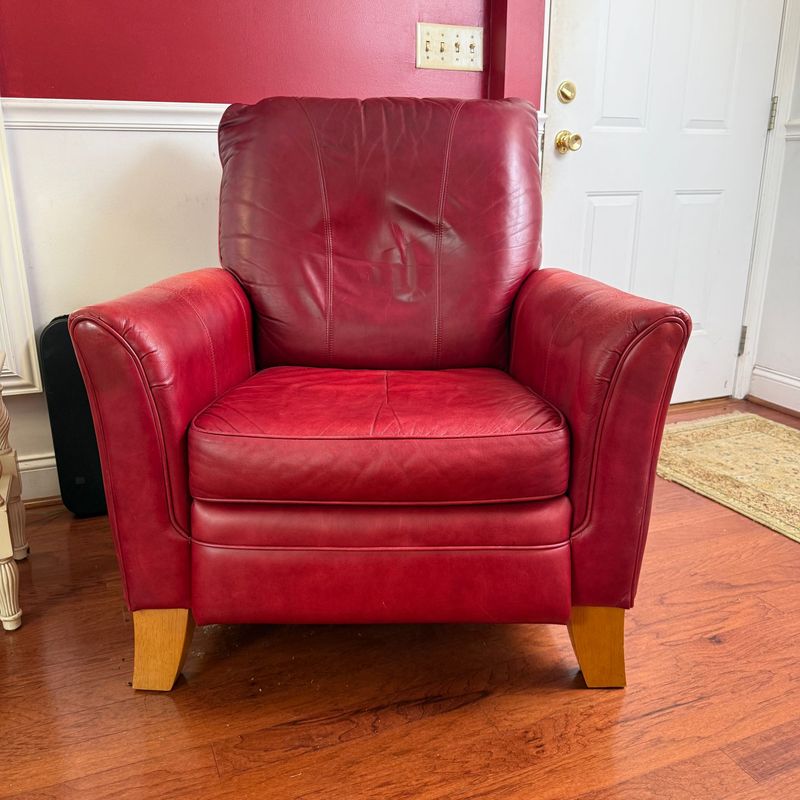 Deep red leather recliner, comfortable, some wear and color variance, leather needs some conditioning 35"W x 32"D