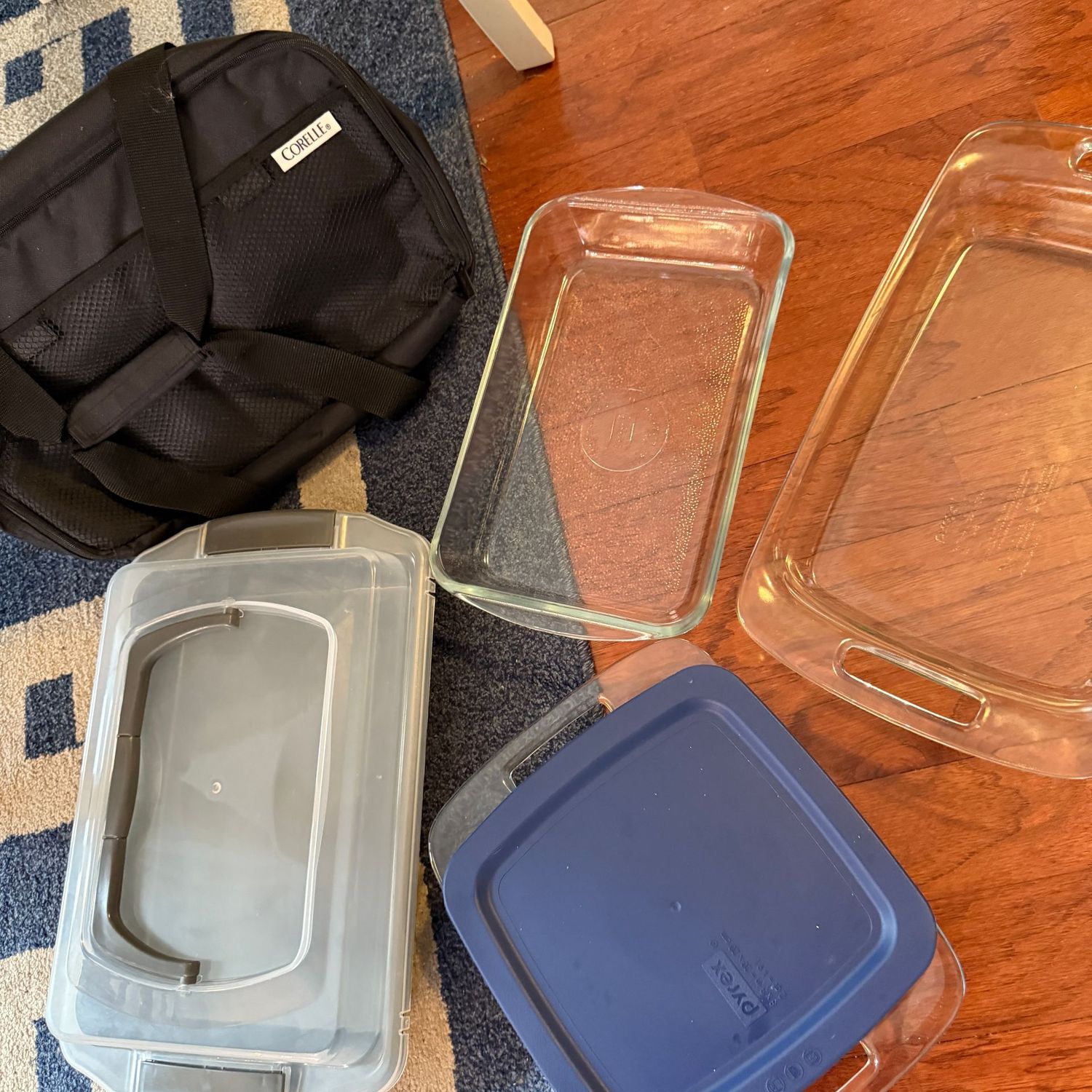 Grouping of glass baking pans, insulated carrier, and metal pan with lid, the largest pan is 9" x 13"