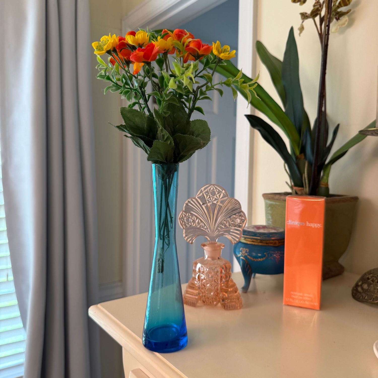 Blue glass vase 7" with orange and yellow flowers