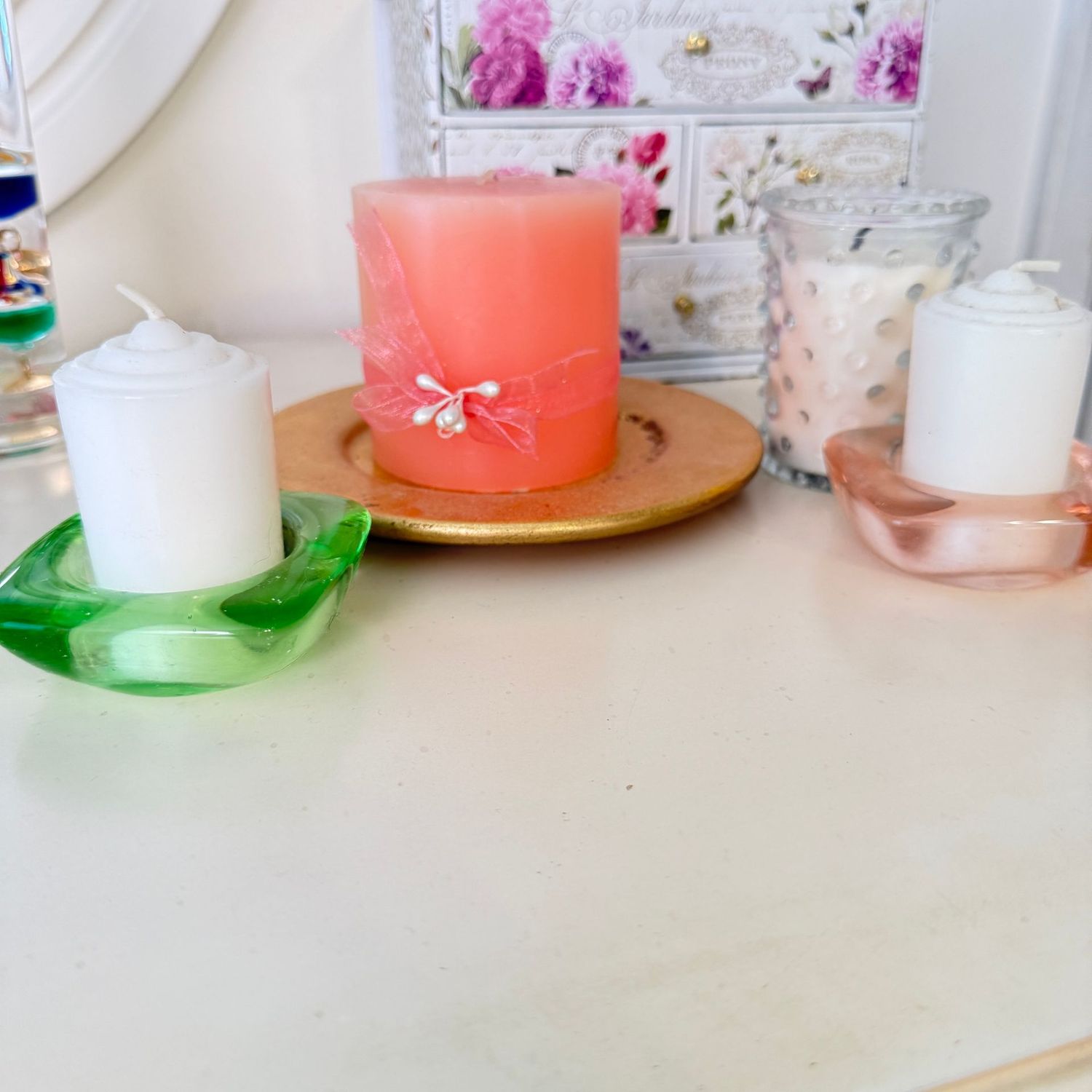 Group of white and peach candles with holders