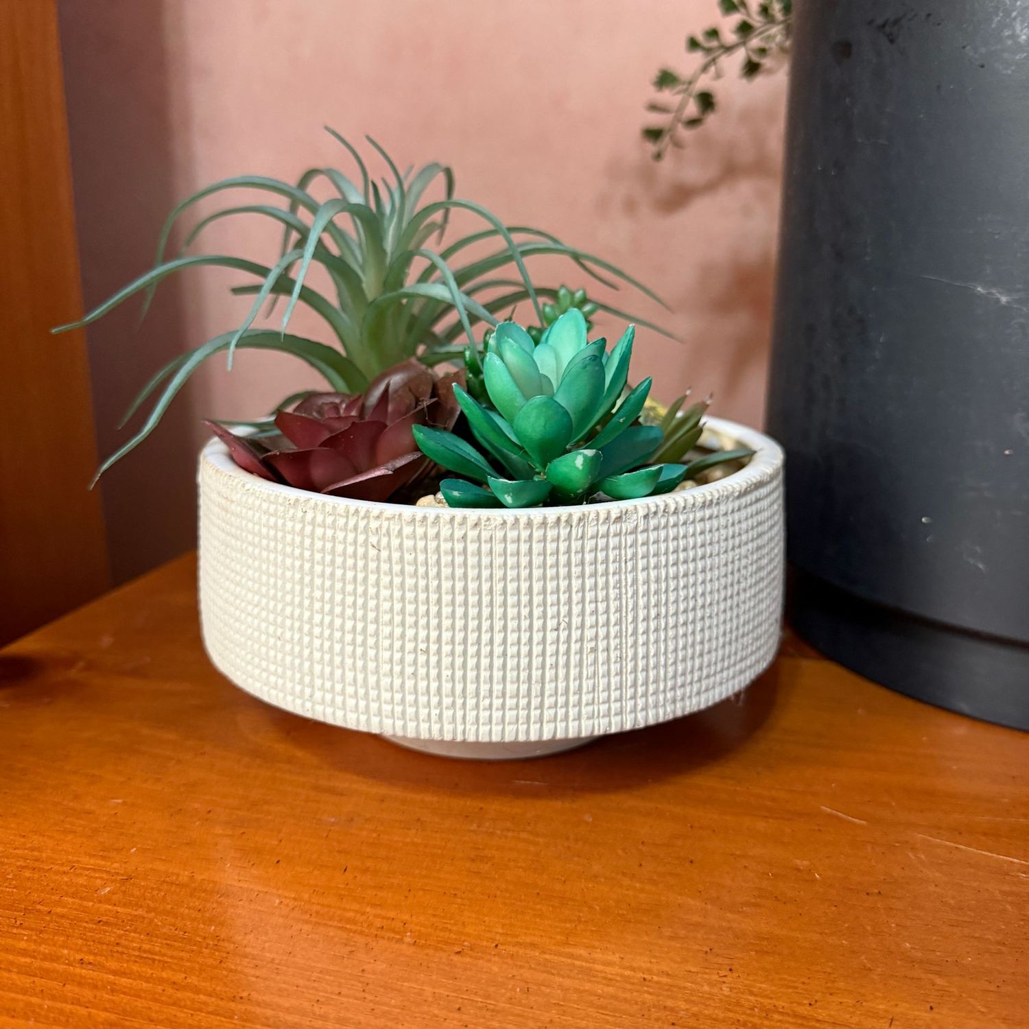 Tan waffle-pattern planter with a variety of faux succulents 6.5"W