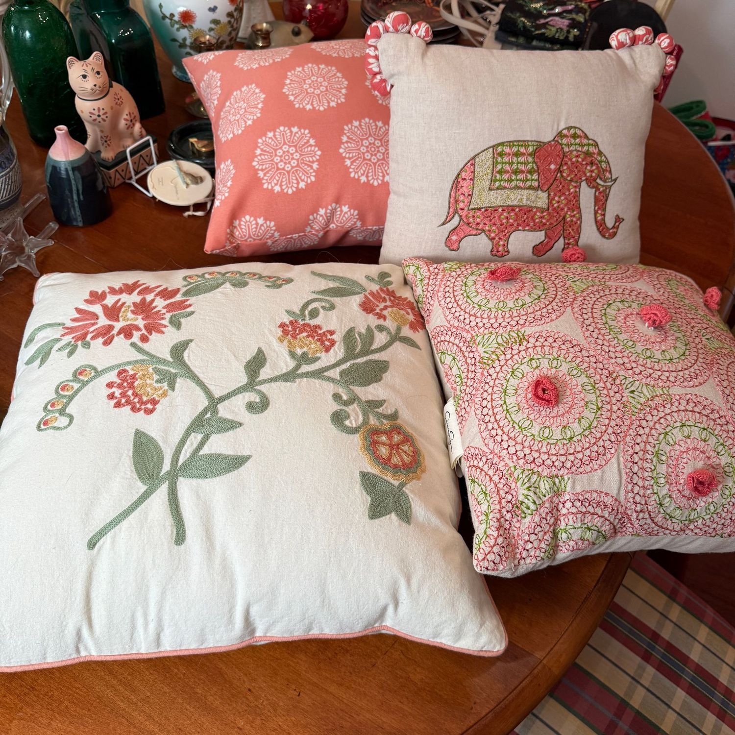 Group of peach, green, and white accent pillows, the largest is 16"