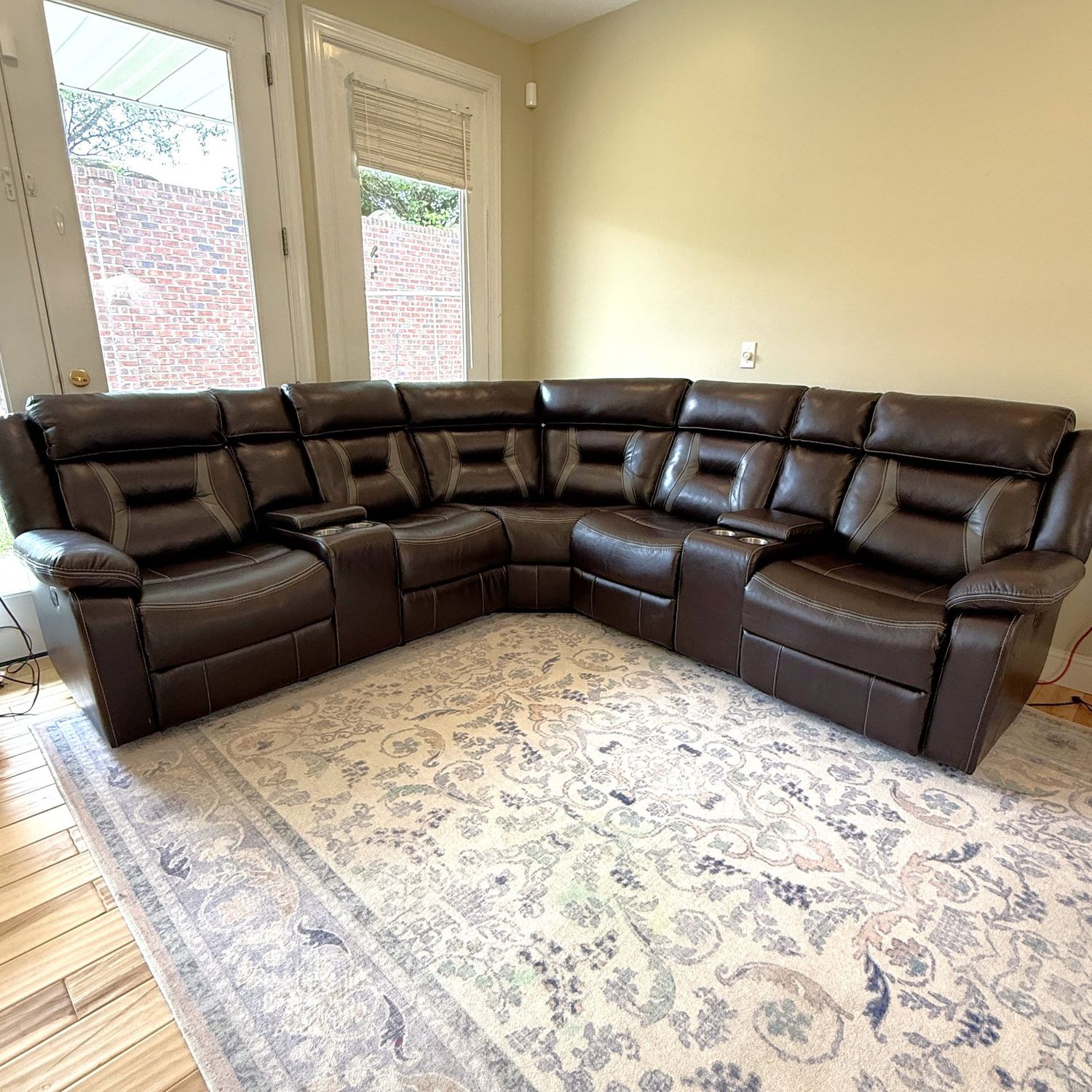 Large 'leatherette' dark brown and grey sectional sofa with reclining ends, cup holders, armrest storage, reclines smoothly, had minor wear spots (mostly on far left arm) 35"D & 7 ft L on each side