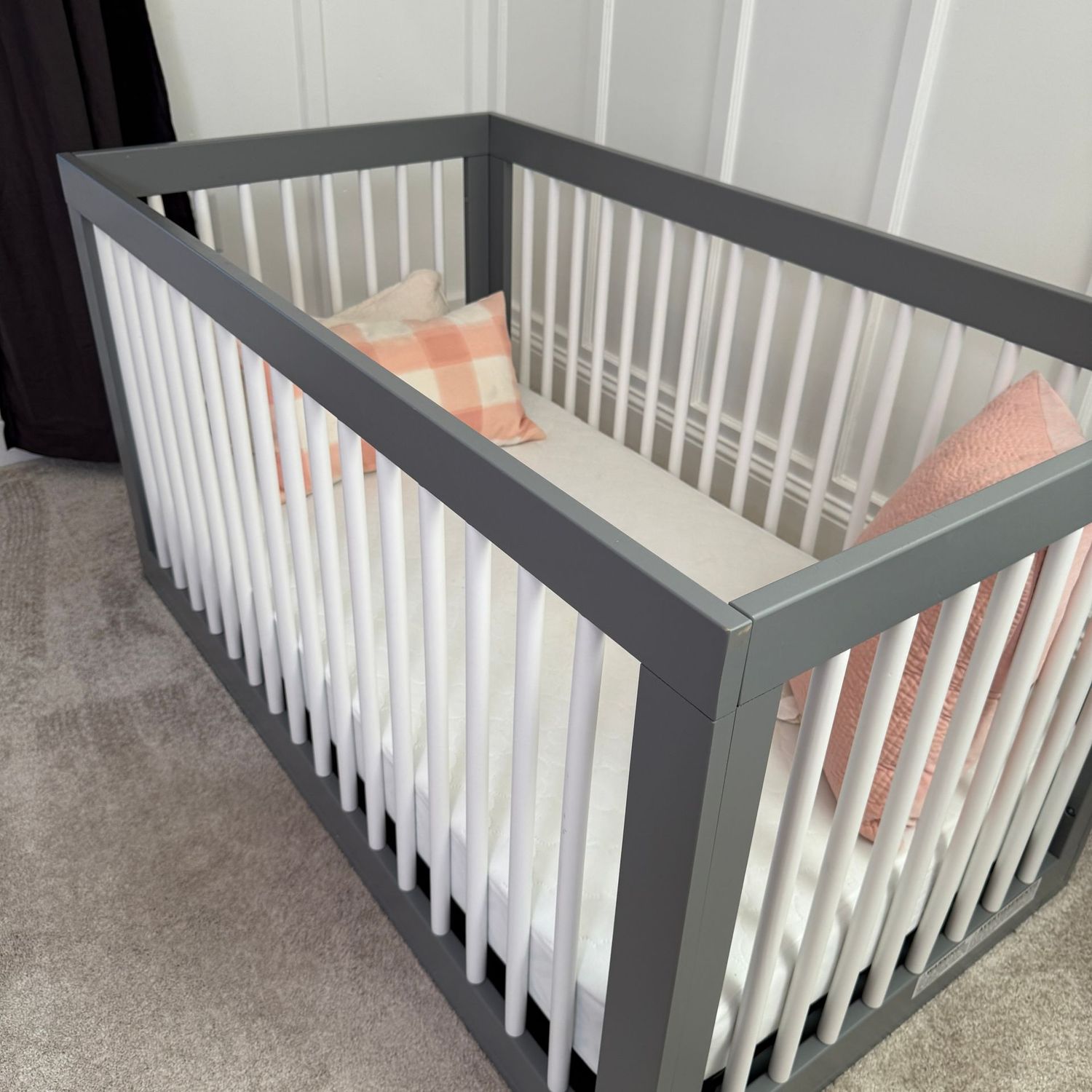 Grey and white floor crib with spring base and mattress, minor wear, a few scratches 52"L x 30"W x 28"H