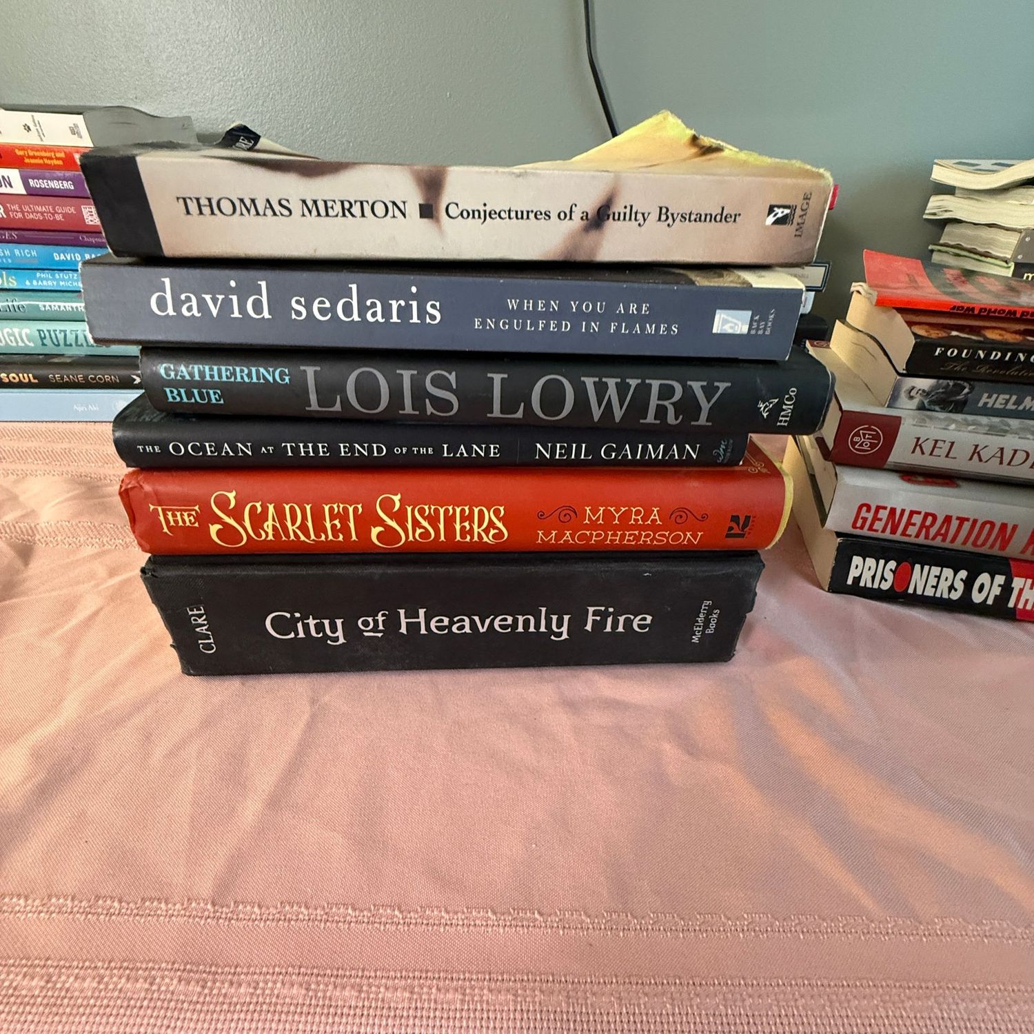Group of books including Gathering Blue and Scarlet Sisters