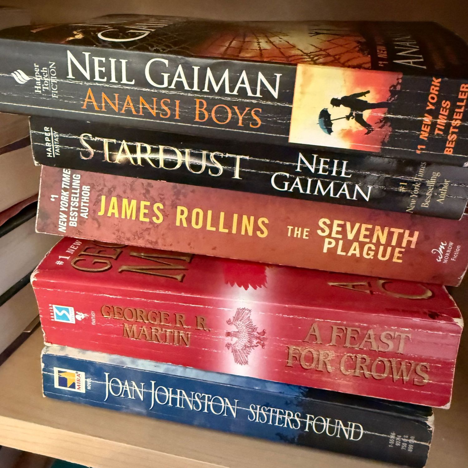 Group of books including Anansi Boys and Sisters Found