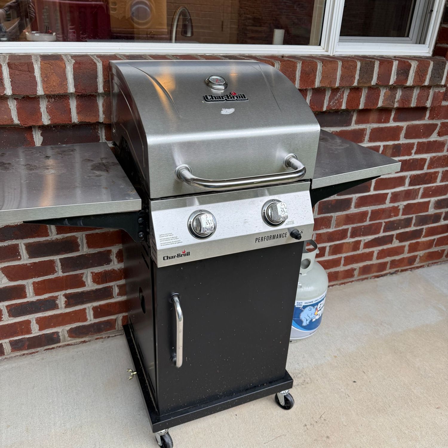 Char-Broil gas grill with drop-side shelves, smaller in size, grates need cleaned, 2 tanks, both partially full, 44"W x 23"D