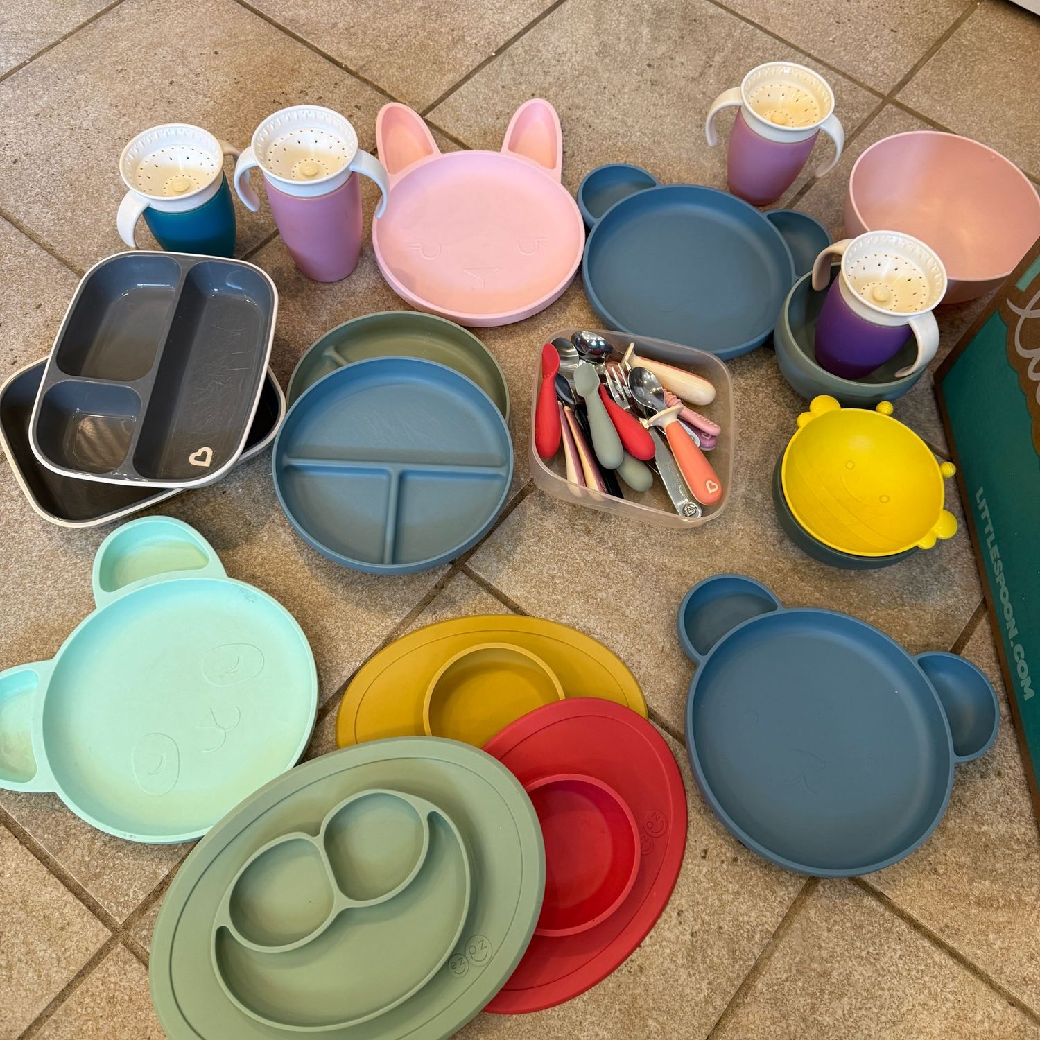 Large lot of toddler bowls, dishes, cups, and utensils, including Cloud Island and EZPZ